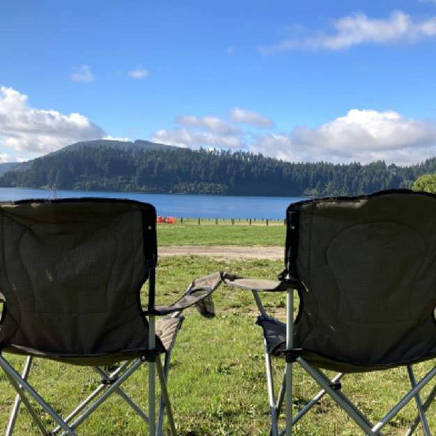 湖の前に椅子が2つ置いてある画像